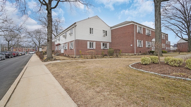 view of property exterior with a yard and brick siding