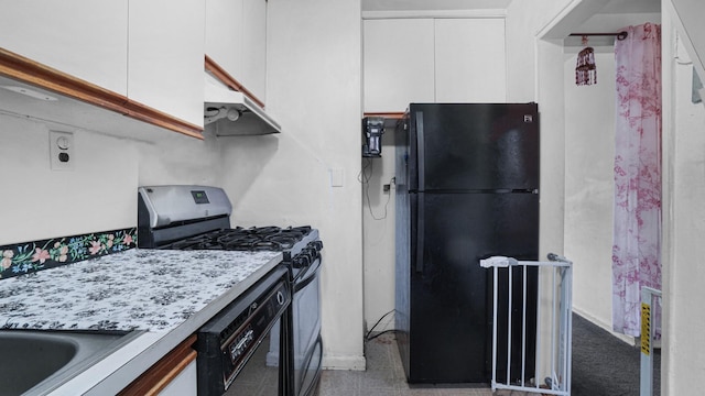 kitchen with under cabinet range hood, light countertops, freestanding refrigerator, white cabinets, and stainless steel gas range