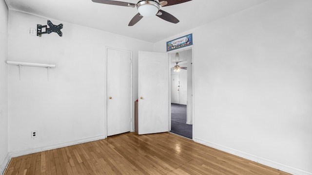 unfurnished bedroom featuring hardwood / wood-style floors, a ceiling fan, and baseboards