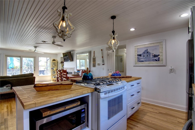 301 Lewis Walk, Cherry Grove, NY 11782 - kitchen with plenty of natural light, open floor plan, wooden counters, stainless steel microwave, and white gas range