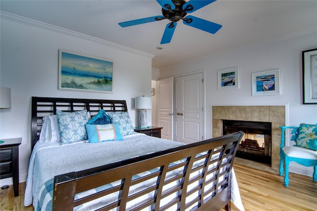 301 Lewis Walk, Cherry Grove, NY 11782 - bedroom with a tile fireplace, ceiling fan, ornamental molding, and wood finished floors