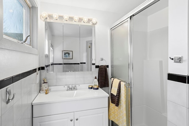 full bathroom featuring a stall shower, tile walls, and vanity