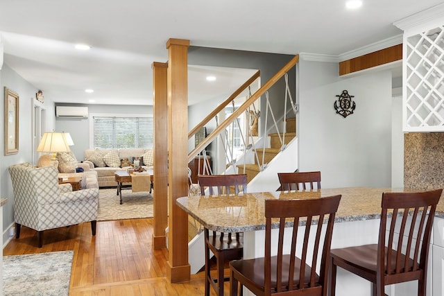 dining room with crown molding, stairway, a wall mounted air conditioner, recessed lighting, and wood finished floors