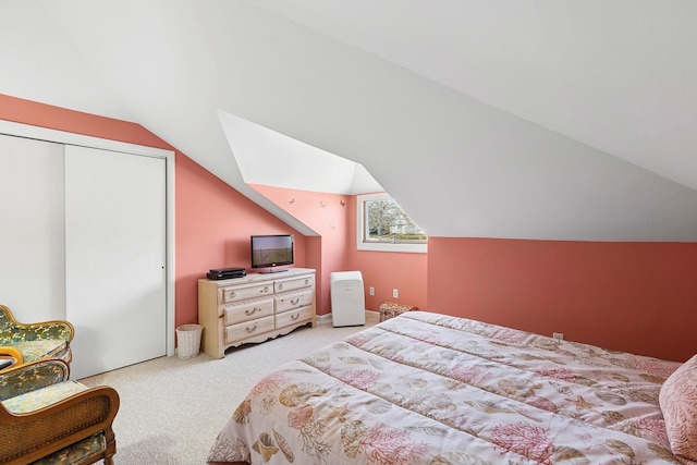 bedroom featuring lofted ceiling, carpet, and a closet