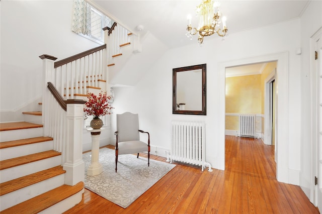 interior space featuring wood-type flooring, a chandelier, and radiator heating unit