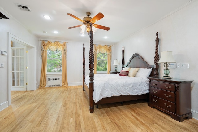 bedroom featuring visible vents, ornamental molding, radiator, and multiple windows