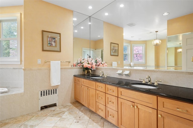 bathroom featuring double vanity, a sink, radiator heating unit, and recessed lighting