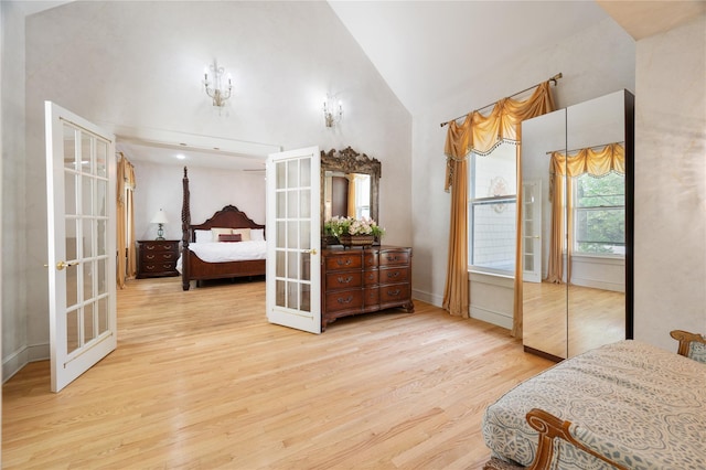 bedroom featuring high vaulted ceiling, french doors, and wood finished floors