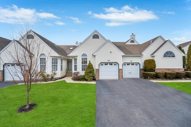 view of front facade featuring aphalt driveway, a chimney, and a front lawn