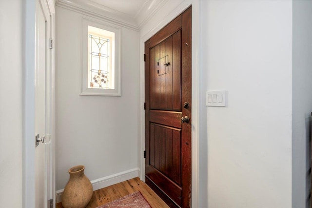 entryway featuring light wood-type flooring, baseboards, and ornamental molding