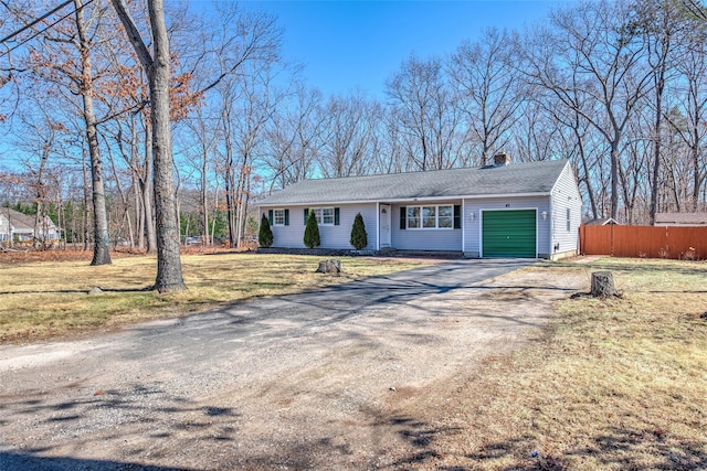 ranch-style house featuring a garage, a front yard, driveway, and fence