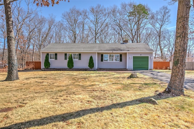 single story home featuring a front lawn, fence, concrete driveway, a chimney, and a garage