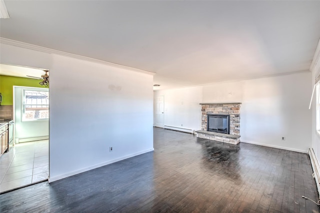 unfurnished living room with baseboard heating, a stone fireplace, ornamental molding, and dark wood-style flooring