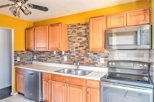 kitchen with tasteful backsplash, light countertops, stainless steel appliances, a ceiling fan, and a sink