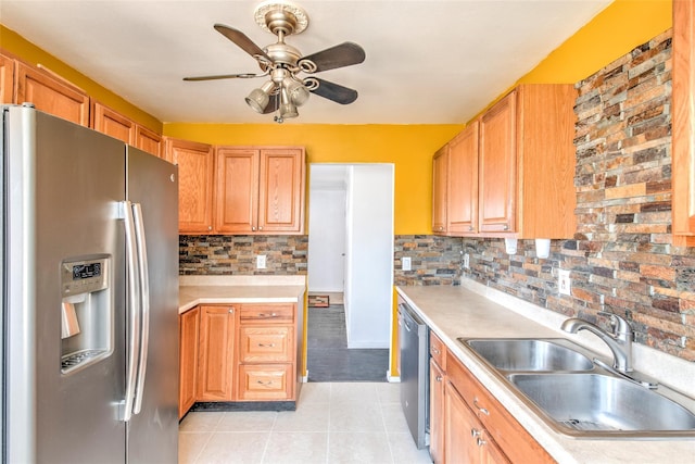 kitchen featuring decorative backsplash, light countertops, appliances with stainless steel finishes, and a sink