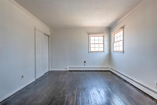 empty room with dark wood-type flooring, baseboard heating, and ornamental molding