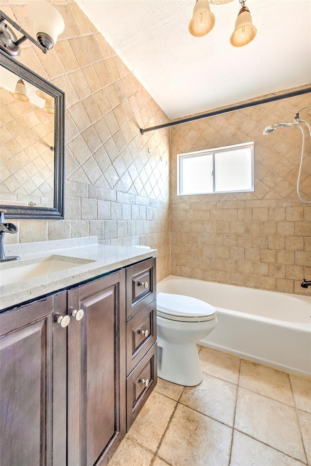 bathroom with toilet, vanity, shower / bathtub combination, a textured ceiling, and tile walls