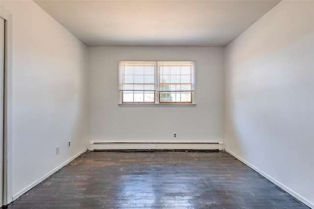 unfurnished room featuring baseboard heating, baseboards, and wood finished floors