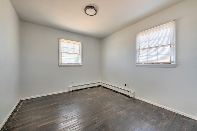 spare room with a wealth of natural light, a baseboard heating unit, baseboards, and hardwood / wood-style flooring