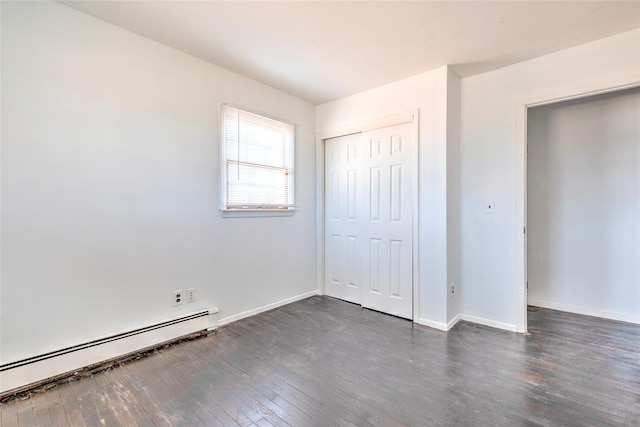 unfurnished bedroom with dark wood-style floors, a closet, baseboards, and a baseboard radiator