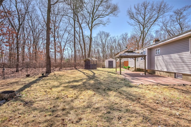 view of yard featuring a storage shed, an outdoor structure, a carport, and a patio area