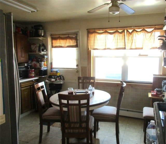 dining room featuring a baseboard radiator, tile walls, and ceiling fan