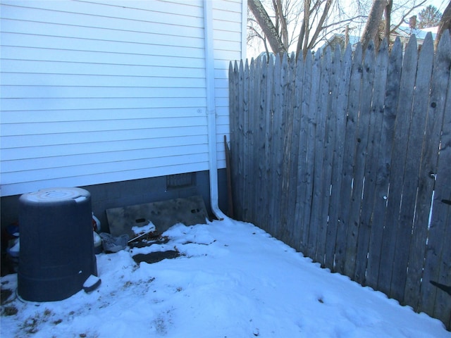 yard layered in snow featuring fence