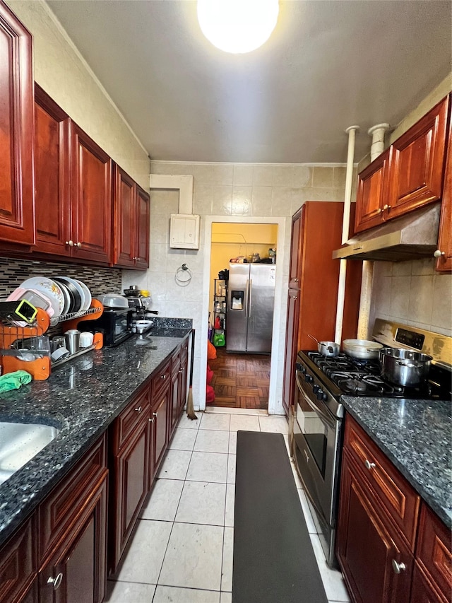 kitchen with under cabinet range hood, decorative backsplash, appliances with stainless steel finishes, and light tile patterned flooring