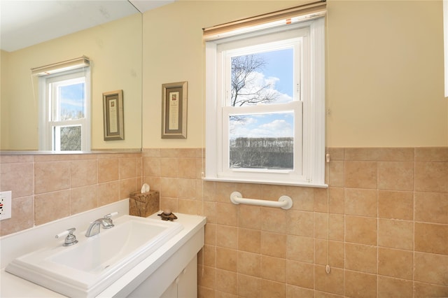 118 Paquatuck Ave, East Moriches, NY 11940 - bathroom with tile walls, a wealth of natural light, vanity, and wainscoting