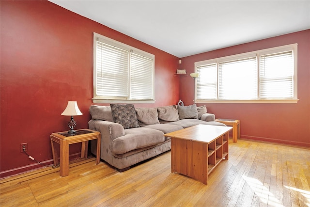 living area with light wood-type flooring and baseboards