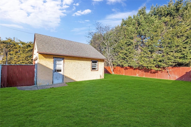 exterior space with stucco siding, a shingled roof, a yard, and fence