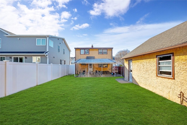 rear view of house with a patio area, a lawn, and a fenced backyard