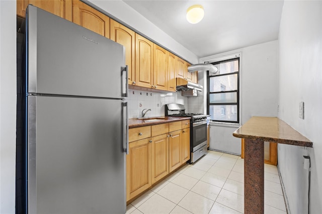 kitchen featuring light tile patterned floors, a sink, decorative backsplash, stainless steel appliances, and under cabinet range hood