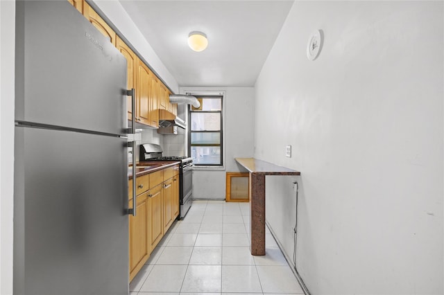 kitchen featuring stainless steel appliances, backsplash, dark countertops, and light tile patterned flooring