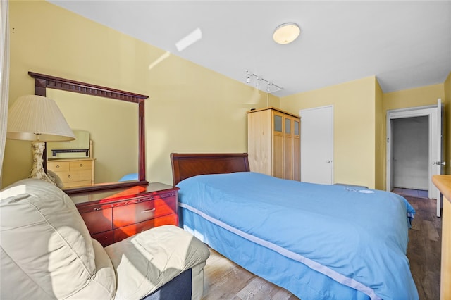 bedroom with wood finished floors and rail lighting