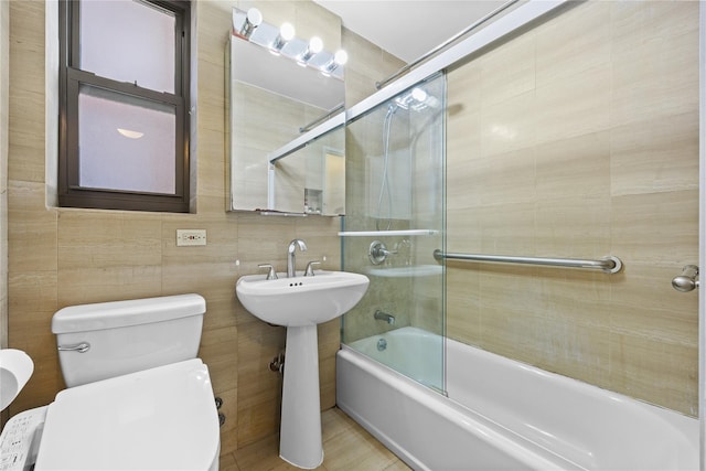 bathroom featuring tile walls, toilet, and shower / washtub combination