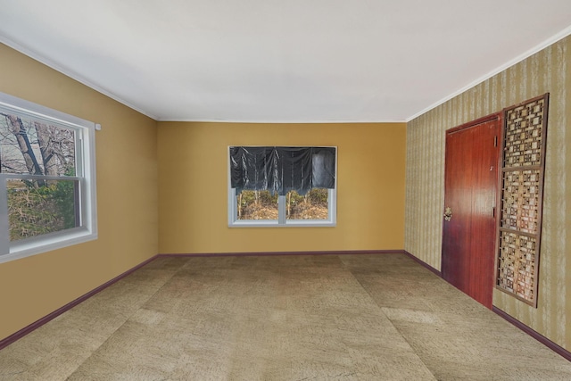 carpeted empty room featuring baseboards and ornamental molding