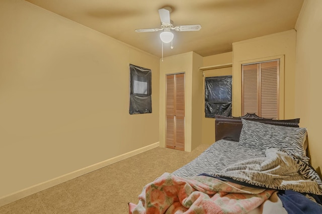 bedroom with baseboards, a ceiling fan, and multiple closets