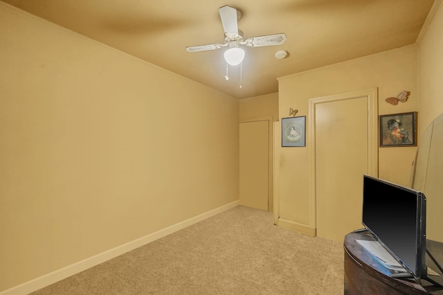 interior space featuring a ceiling fan, baseboards, carpet floors, and ornamental molding