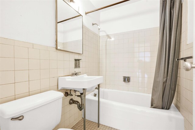 180 W End Ave Unit 23G, New York Manhattan, NY 10023 - full bath with tile patterned flooring, tile walls, toilet, and shower / bath combo with shower curtain