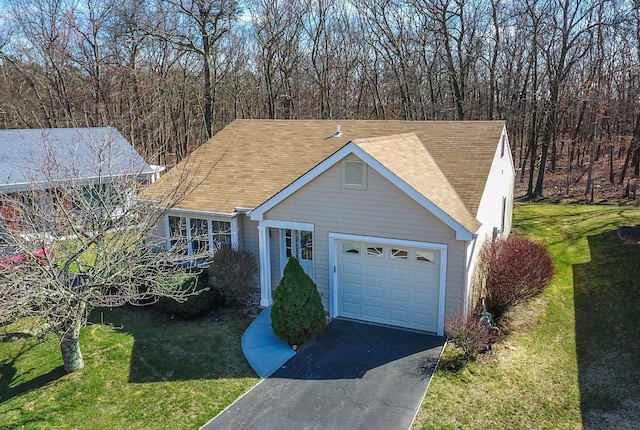 view of front facade with aphalt driveway, a front yard, an attached garage, and a tiled roof