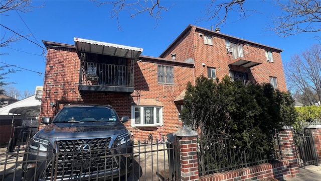 view of front of house with brick siding, a garage, a gate, and fence