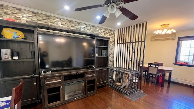 living area with baseboards, ceiling fan, an AC wall unit, ornamental molding, and dark wood-style flooring