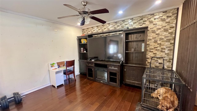 living room featuring dark wood-style floors, baseboards, a barn door, ceiling fan, and crown molding