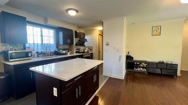 kitchen with dark wood-style flooring, a sink, light countertops, appliances with stainless steel finishes, and tasteful backsplash