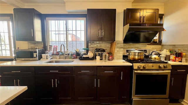 kitchen featuring backsplash, light countertops, ornamental molding, appliances with stainless steel finishes, and a sink