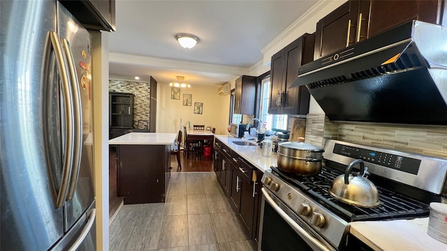 kitchen featuring a sink, decorative backsplash, light countertops, under cabinet range hood, and appliances with stainless steel finishes