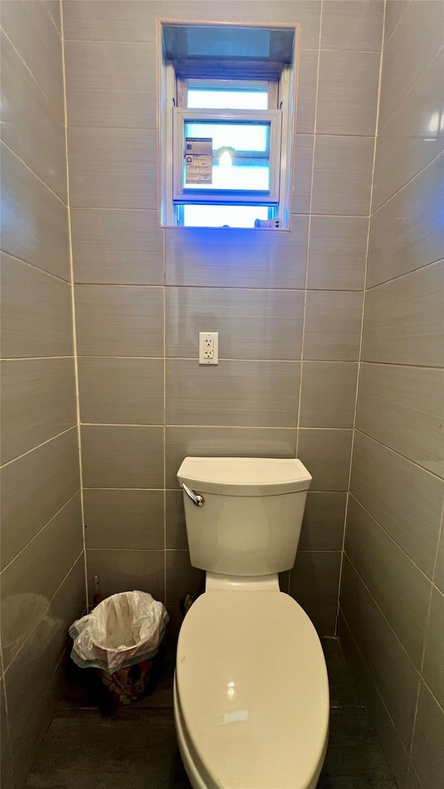 bathroom with tile walls and toilet