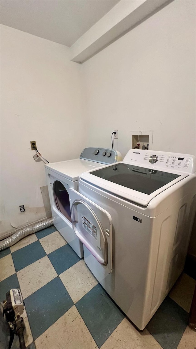 clothes washing area featuring washer and dryer, laundry area, and tile patterned floors