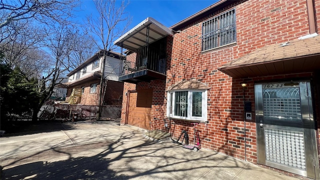 exterior space featuring brick siding and a balcony